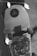 A skateboard with a graphic design featuring a stylized character. It is decorated with a string of small ghost lights, creating a playful and spooky atmosphere. The setting is dimly lit, focusing more on the skateboard and the lights.