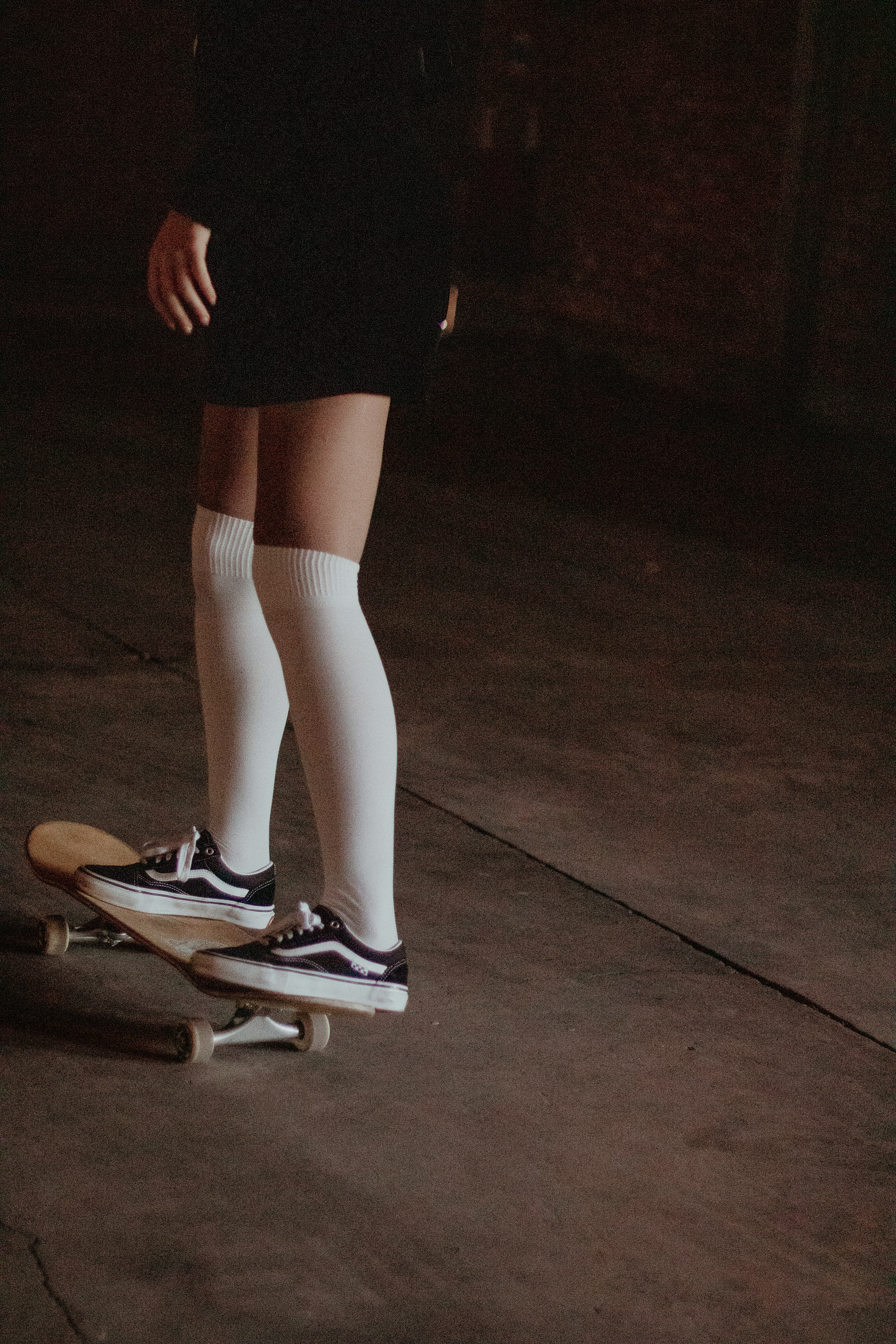 une personne faisant de la planche à roulettes dans une pièce sombre