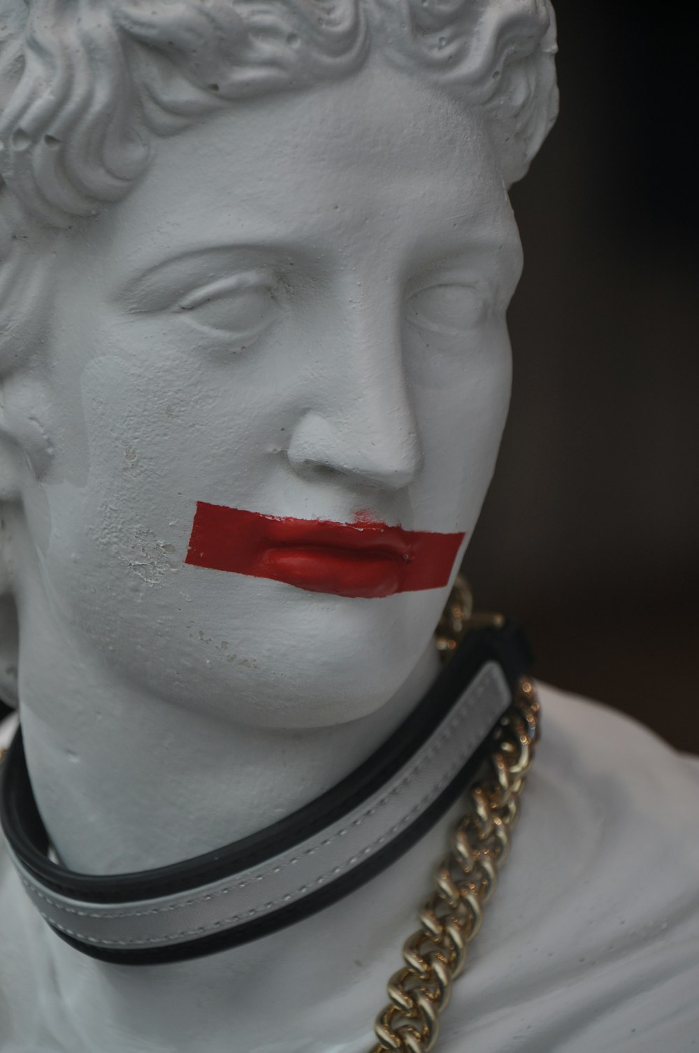 a white statue with a red lip painted on it