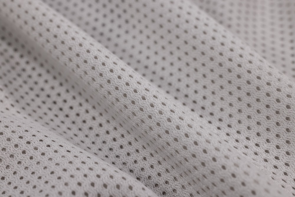 a close up of a white fabric with small dots