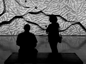 Two stylized figures engaged in a thoughtful debate, rendered with clean lines and soft colors.