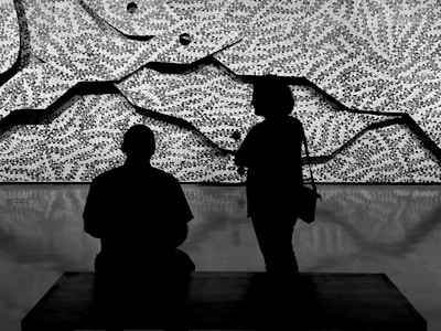 Two stylized figures engaged in a thoughtful debate, rendered with clean lines and soft colors.