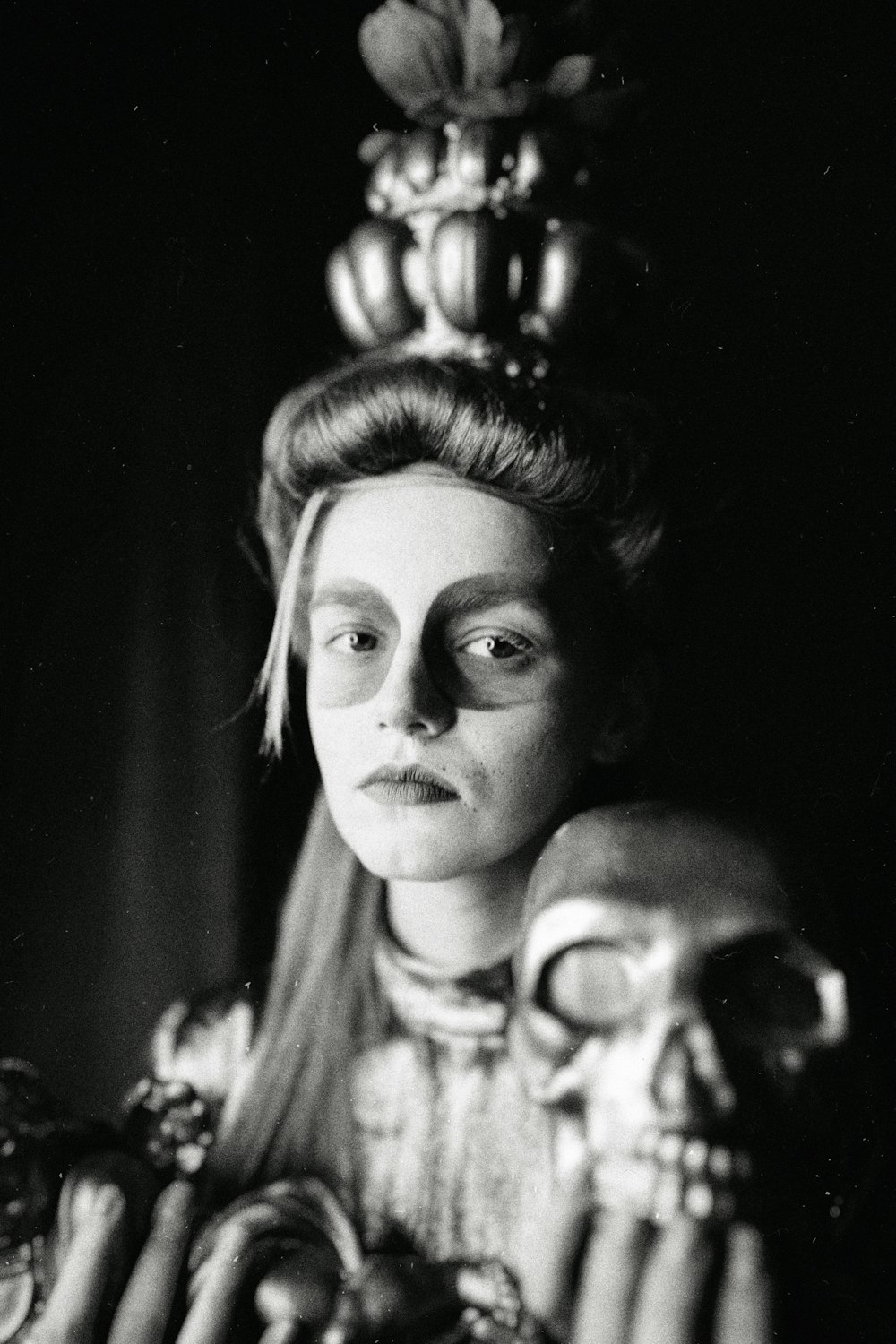 a black and white photo of a woman holding a skull