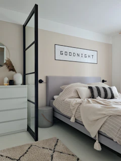 a bedroom with a bed, dresser and mirror