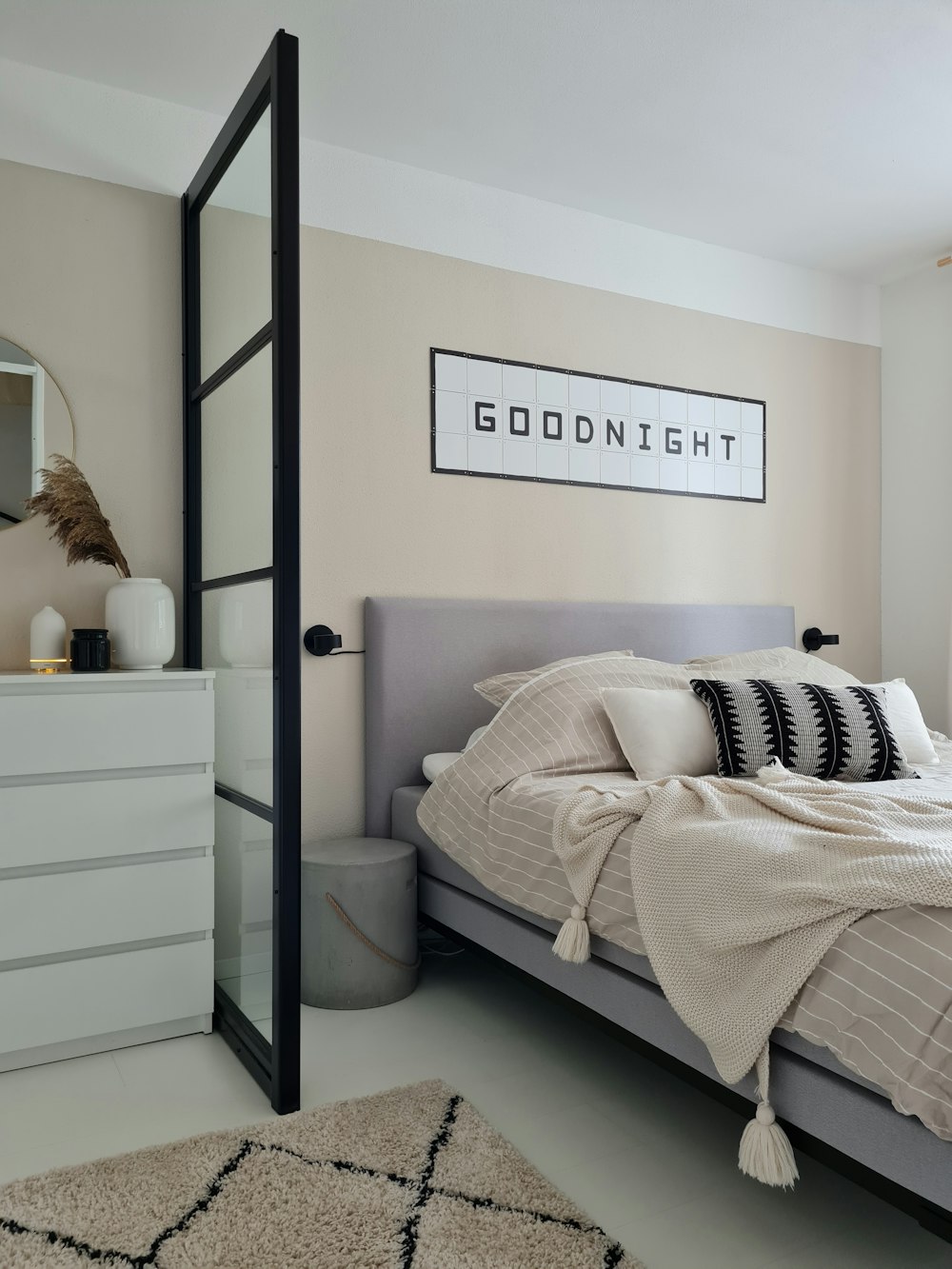 a bedroom with a bed, dresser and mirror