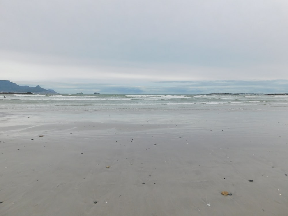 une plage de sable avec des vagues qui arrivent sur le rivage