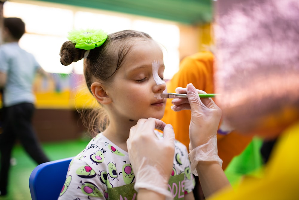 a little girl getting her make up done