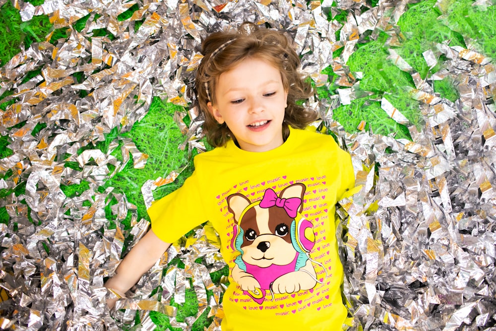 a little girl laying on a bed of tin foil