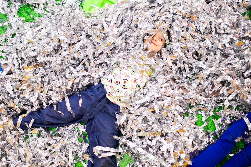 a child laying on a pile of shredded paper