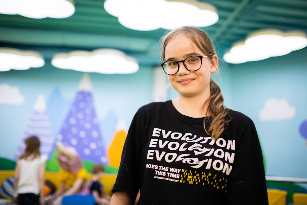 a young girl wearing a black shirt and glasses