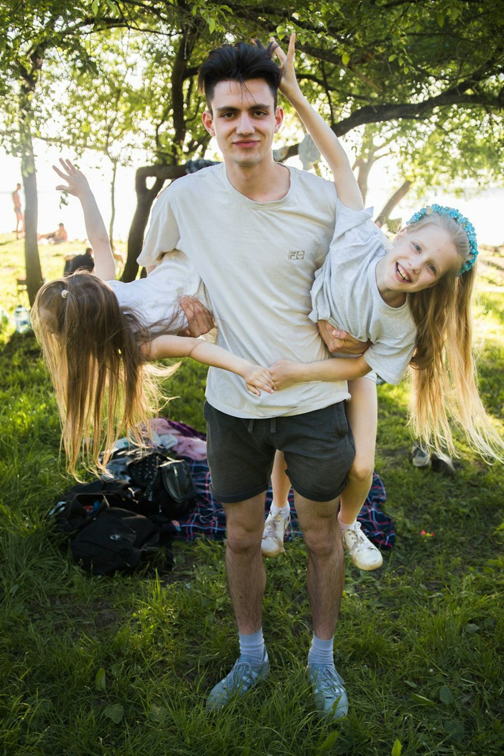 a man holding two little girls in his arms