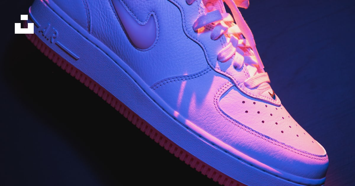 Une paire de baskets blanches et rouges sur une surface noire photo ...