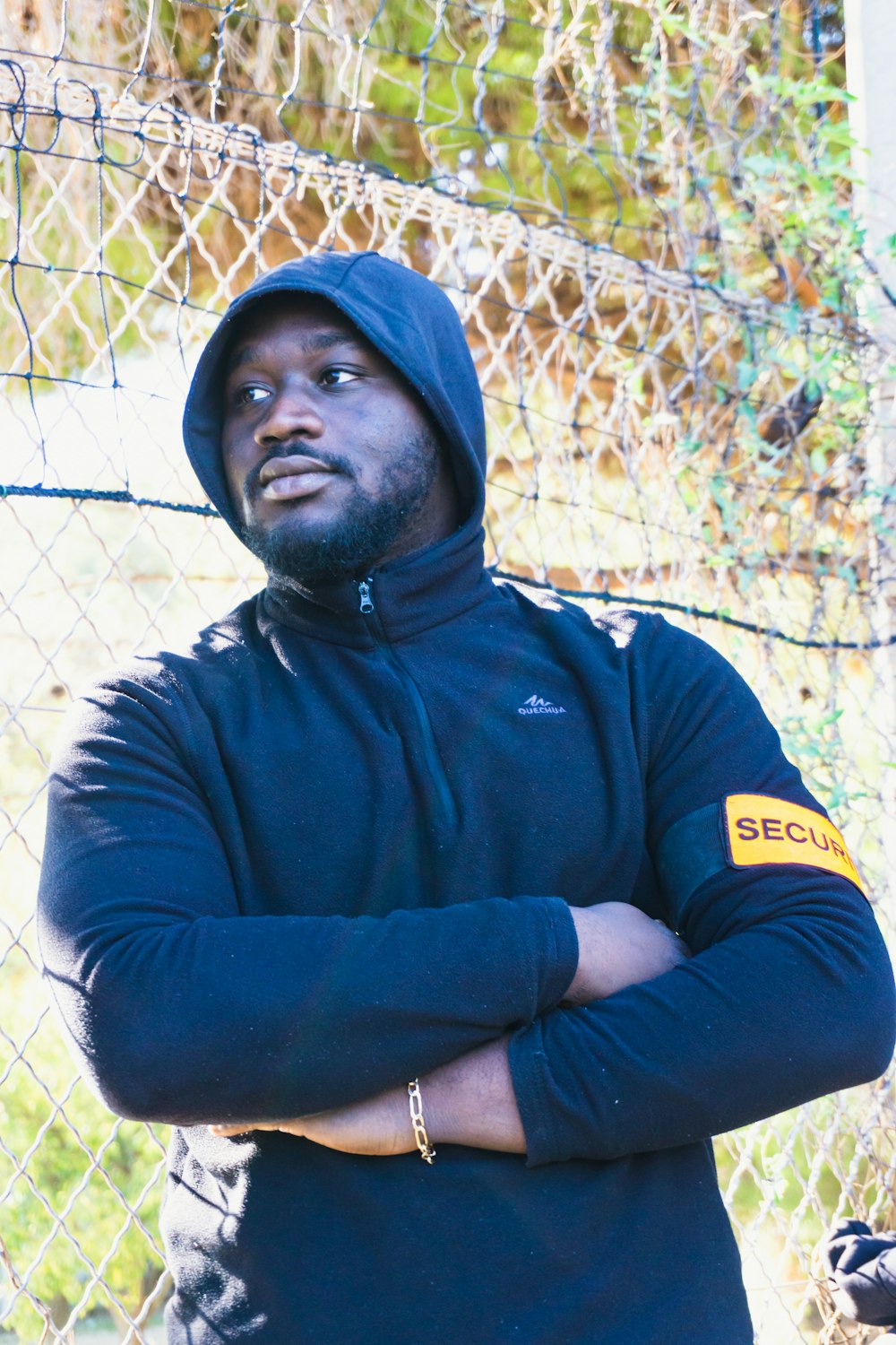 a man standing in front of a chain link fence