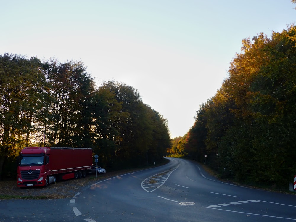 a red semi truck driving down a curvy road