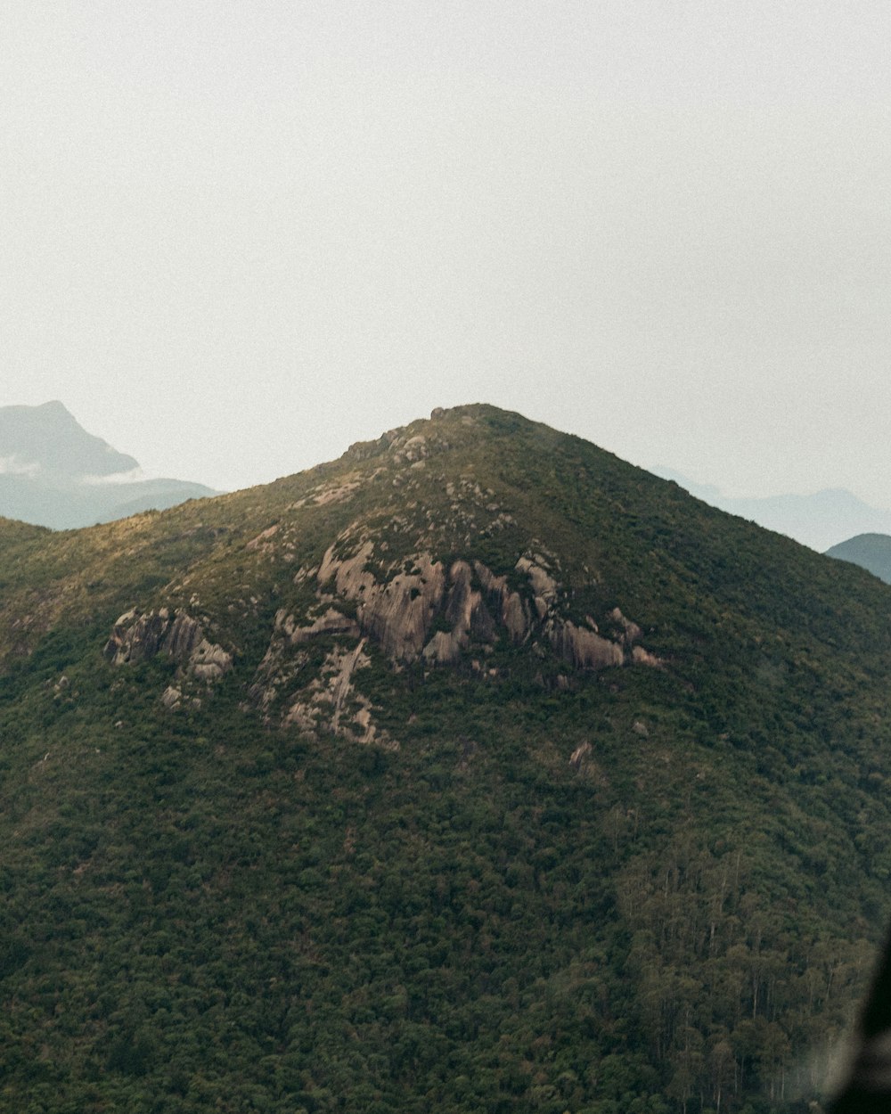 a view of a mountain with a plane flying over it