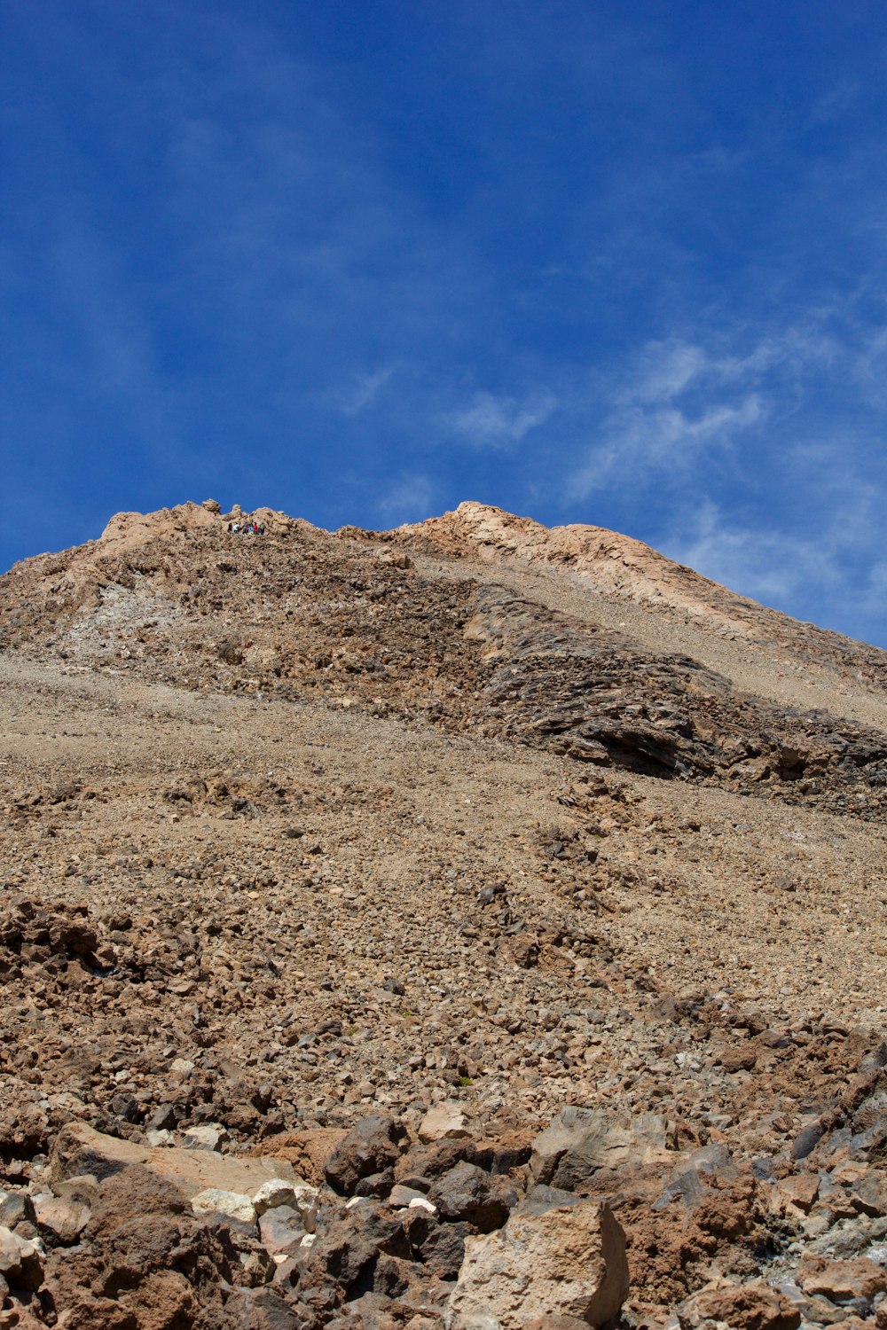 a rocky mountain with a blue sky in the background