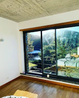 A serene hotel suite bedroom with floor-to-ceiling windows and minimalist decor.