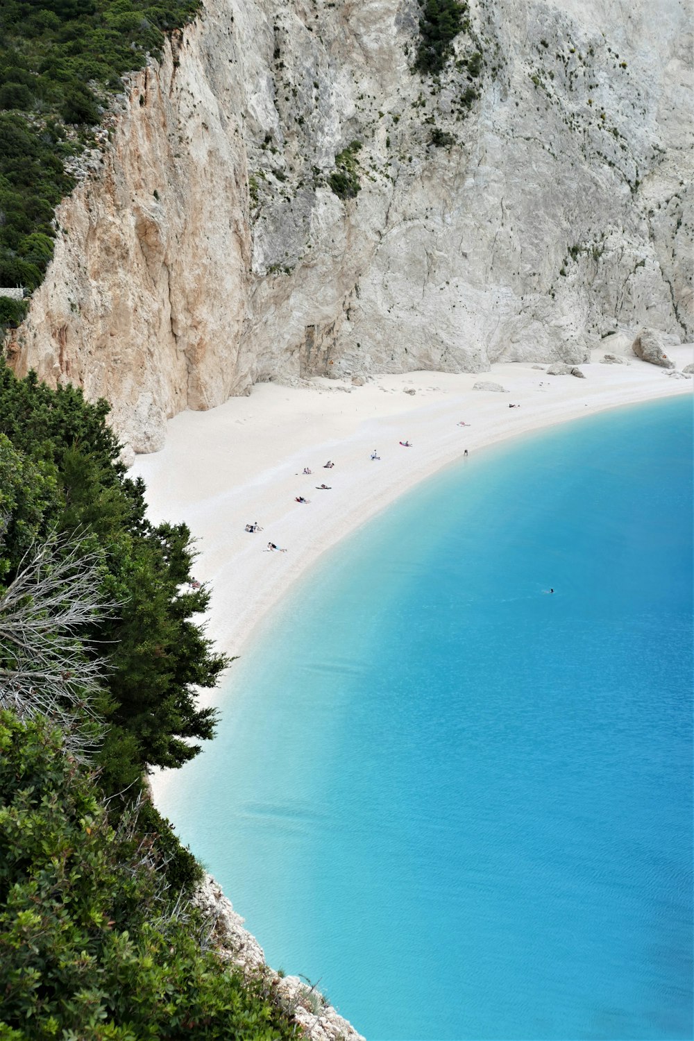 a white sandy beach next to a cliff