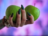 a woman holding two green apples in her hands