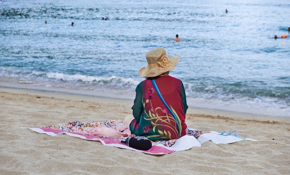 a person sitting on a towel on a beach