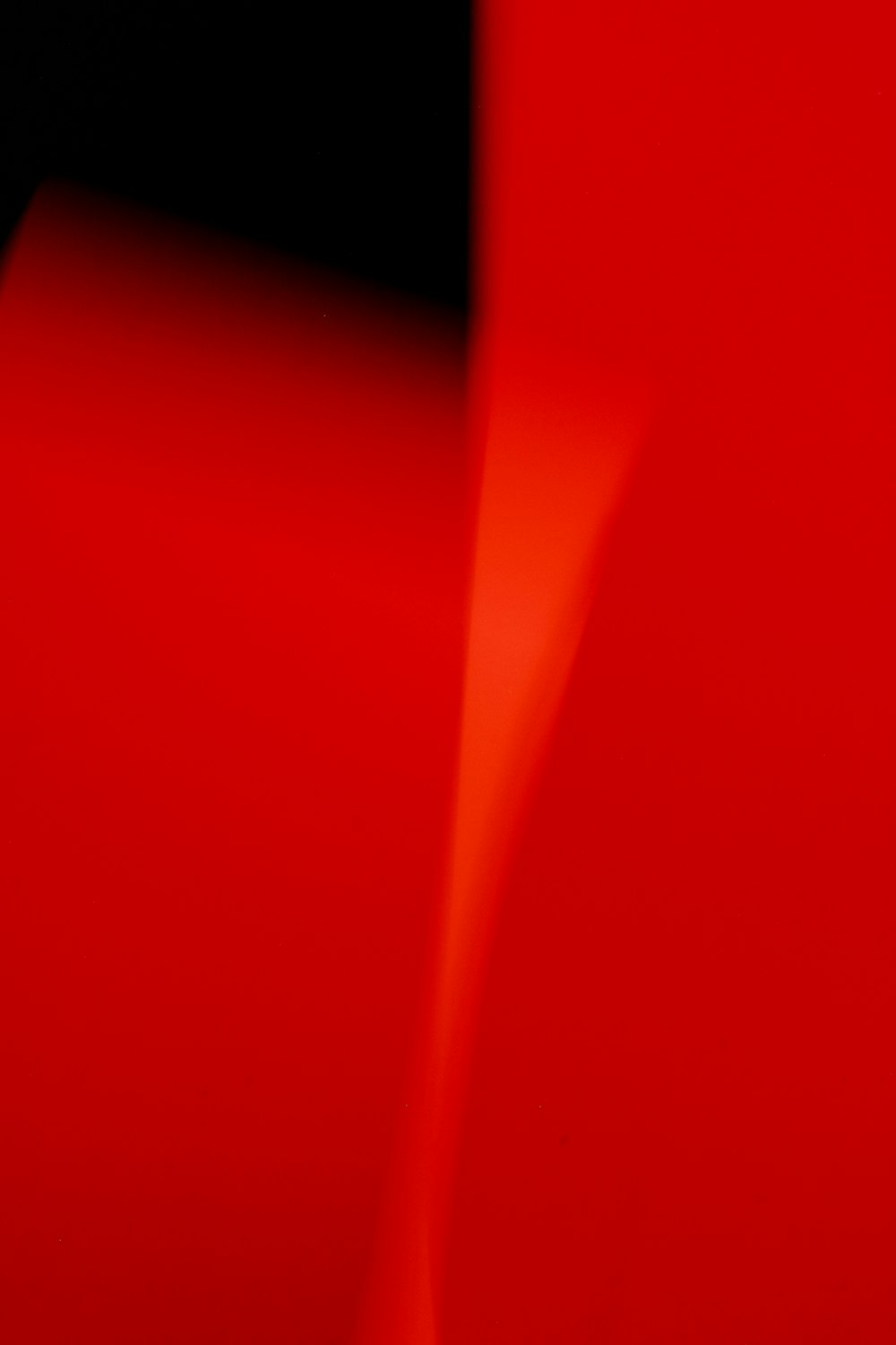a close up of a red object with a black background