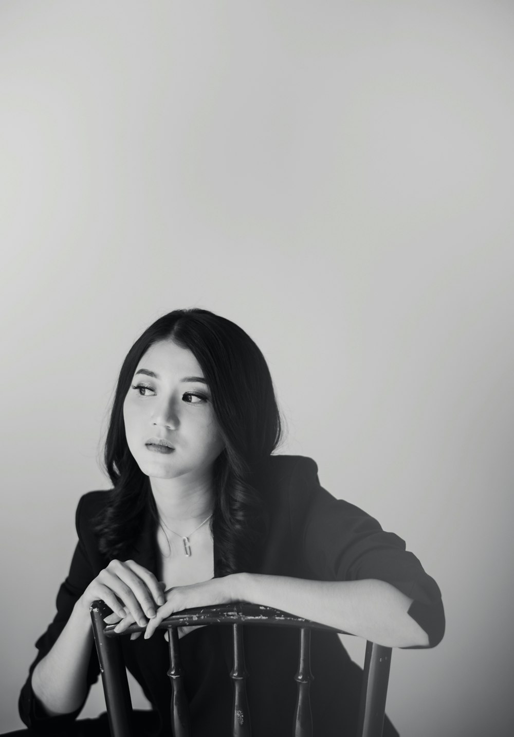 a black and white photo of a woman sitting in a chair