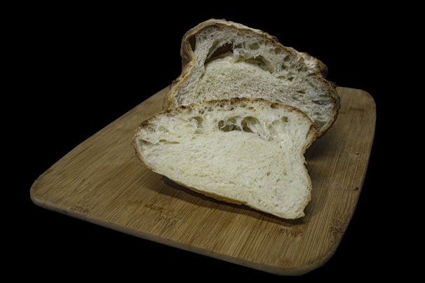 A rustic wooden board displaying freshly baked artisan bread with a crispy crust and soft interior.