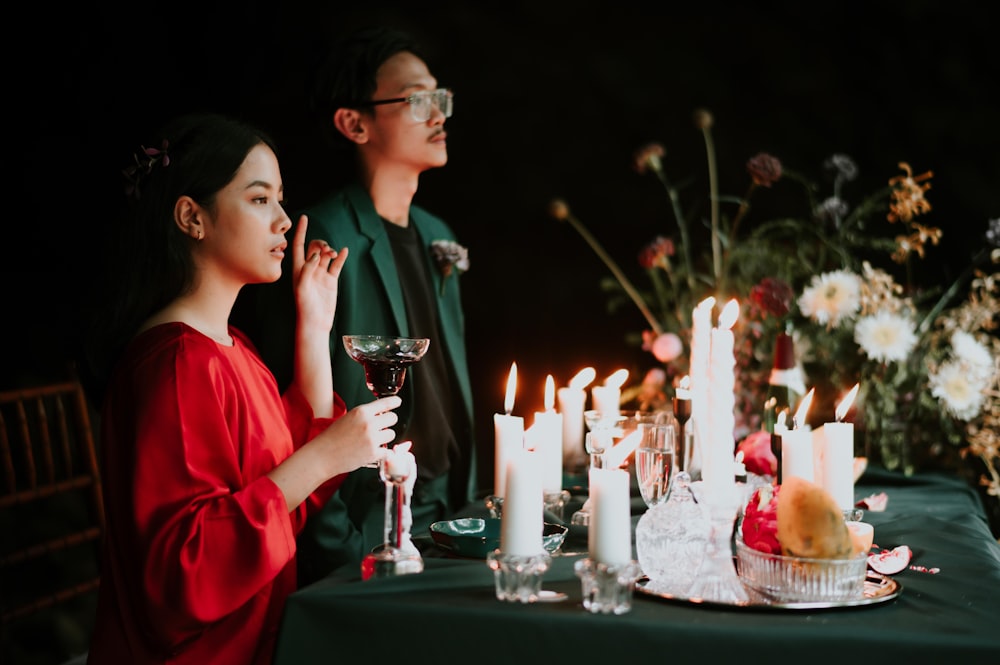 a man and a woman sitting at a table with candles
