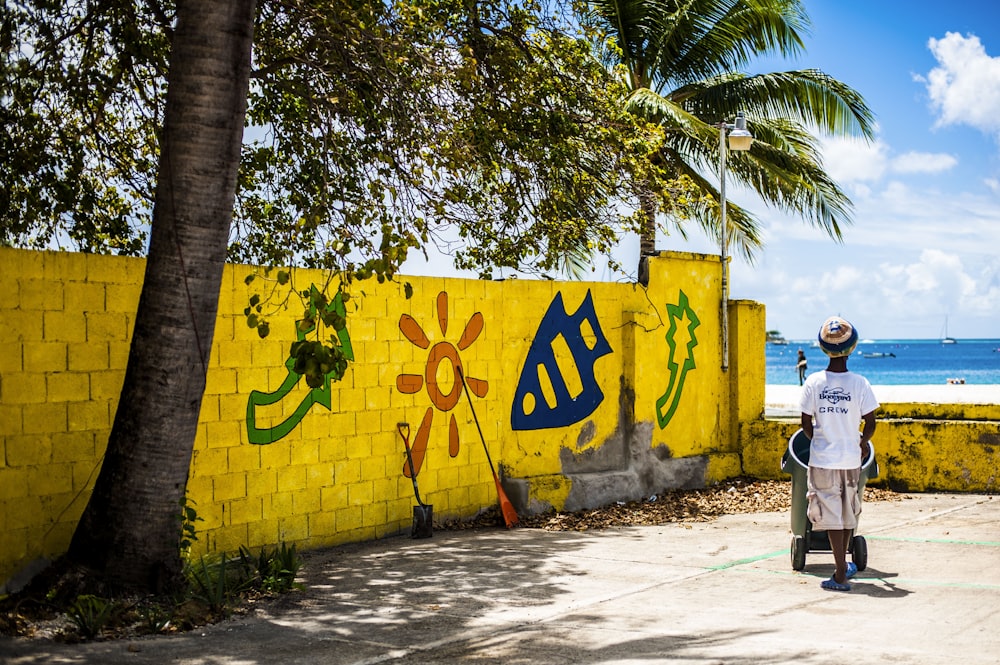 a man standing in front of a yellow wall