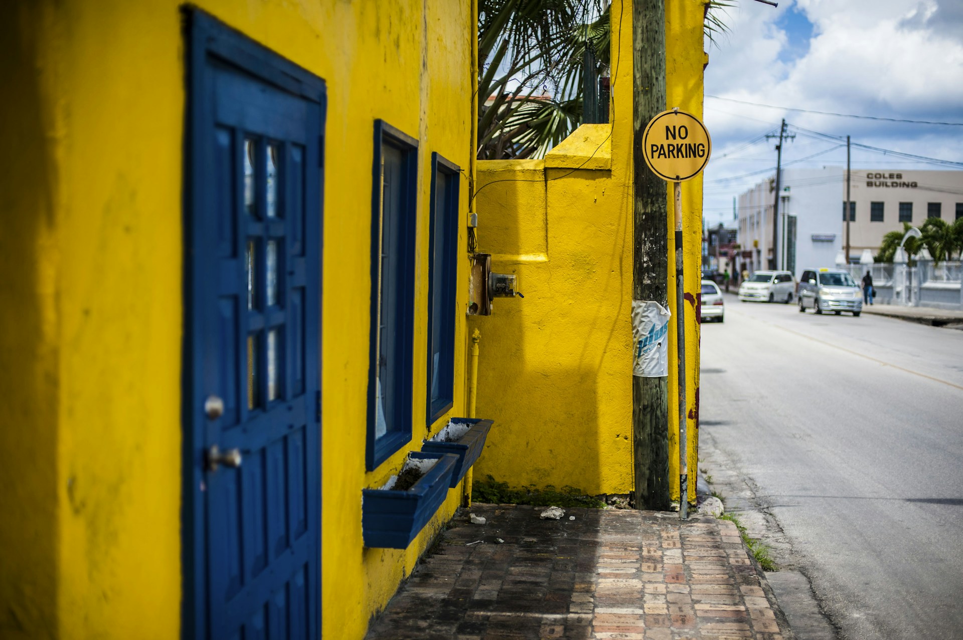 a yellow building with a blue door and window