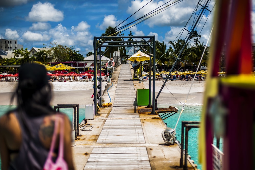 a woman standing on a pier next to a body of water