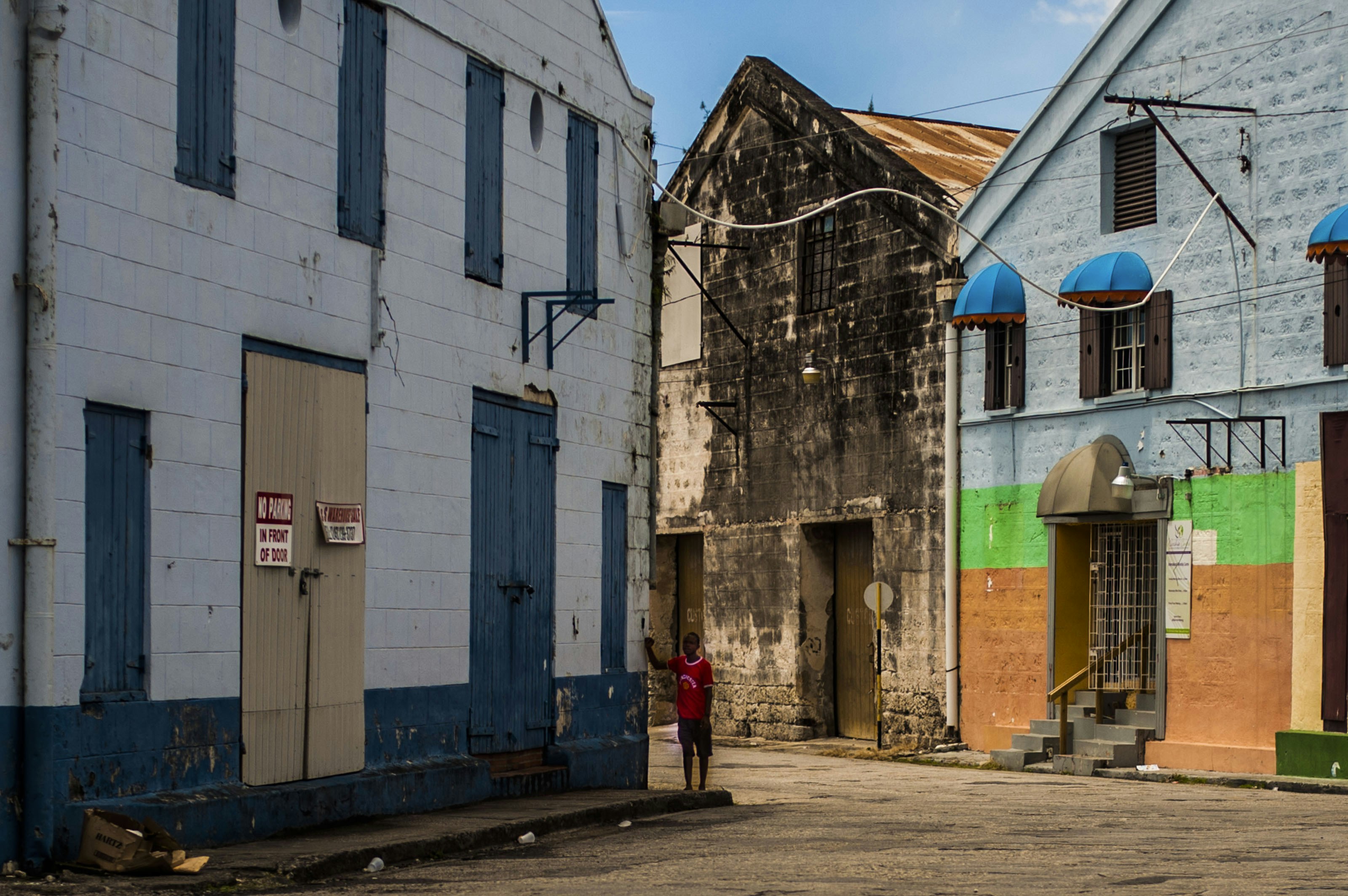 a person standing in an alley between two buildings, 