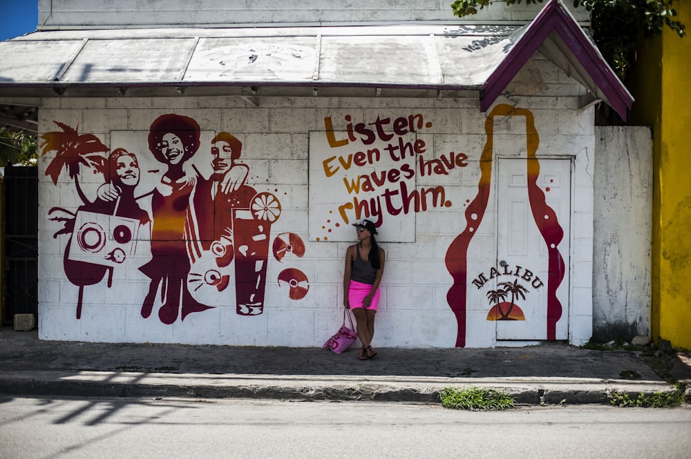 a woman standing in front of a wall covered in graffiti