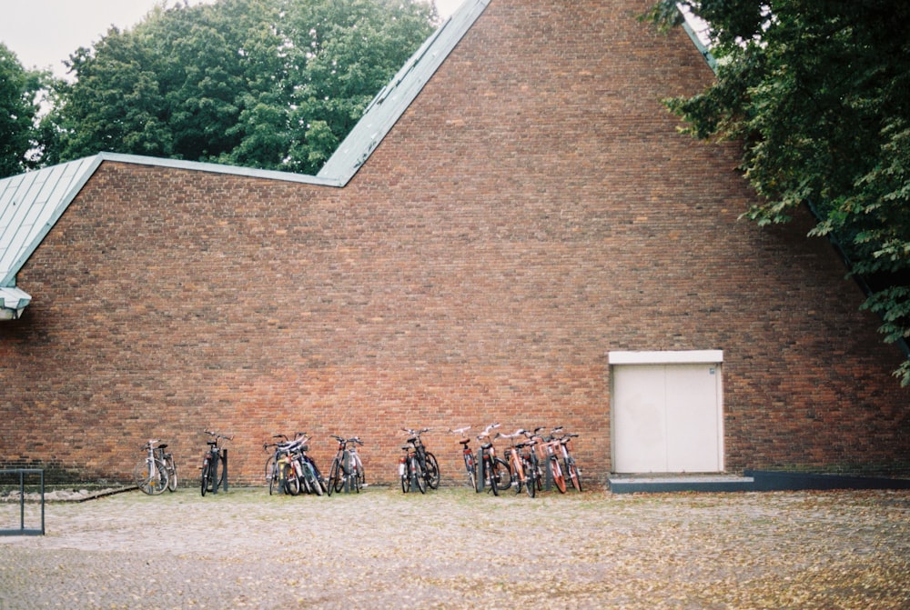 a group of bicycles parked in front of a brick building