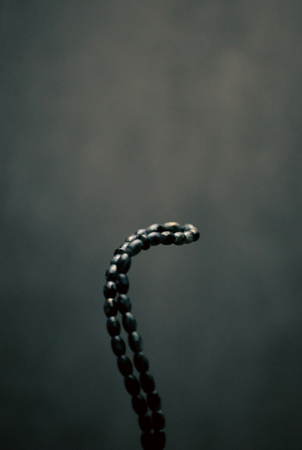 a black beaded necklace on a black background