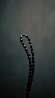 Close-up of an ancient Harappan bead necklace glowing softly against a dark background