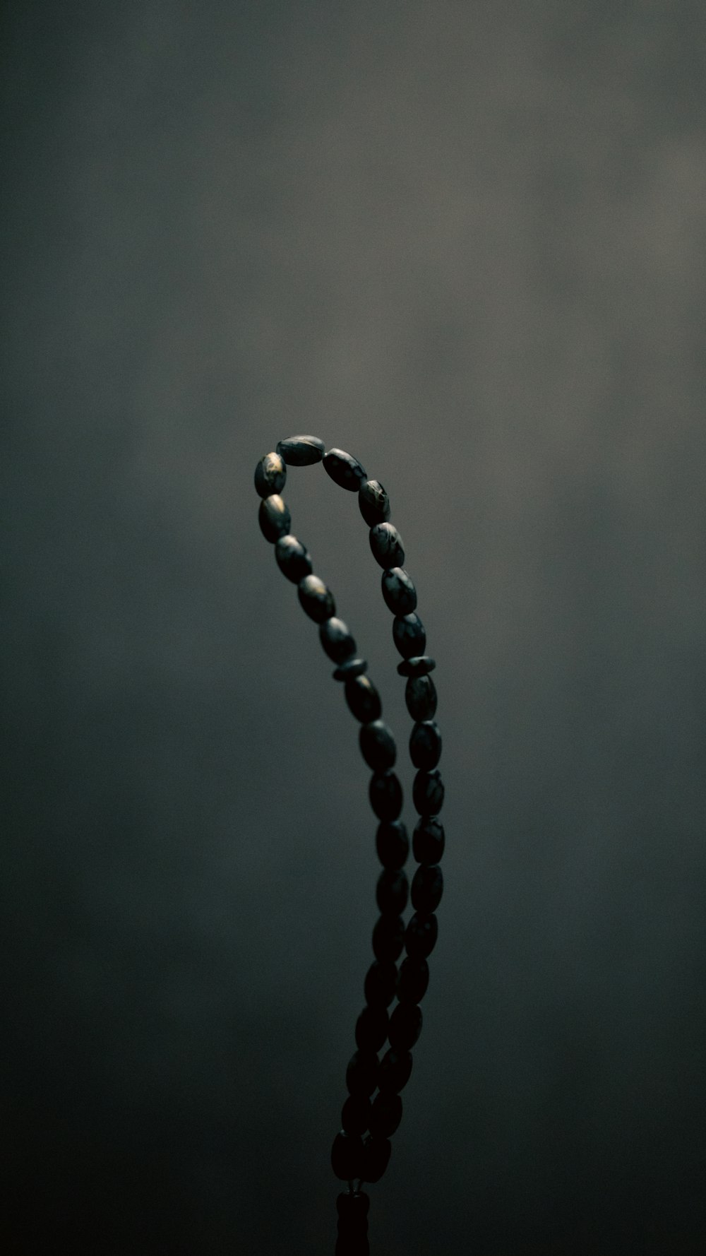 a black beaded necklace with a black background