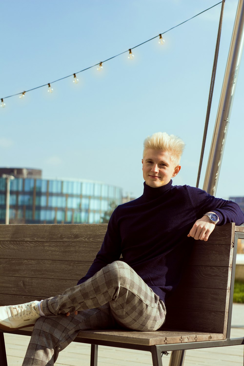 a man sitting on a wooden bench in a park