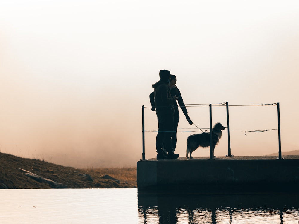 a person and a dog standing on a dock