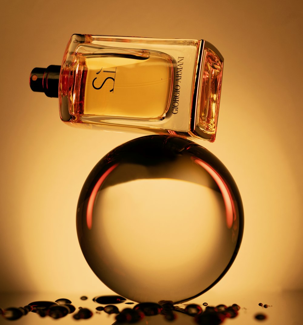 a bottle of perfume sitting on top of a round object