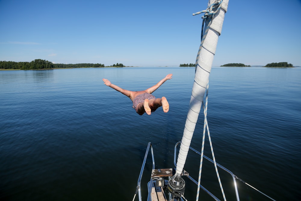 a man diving into the water from a boat