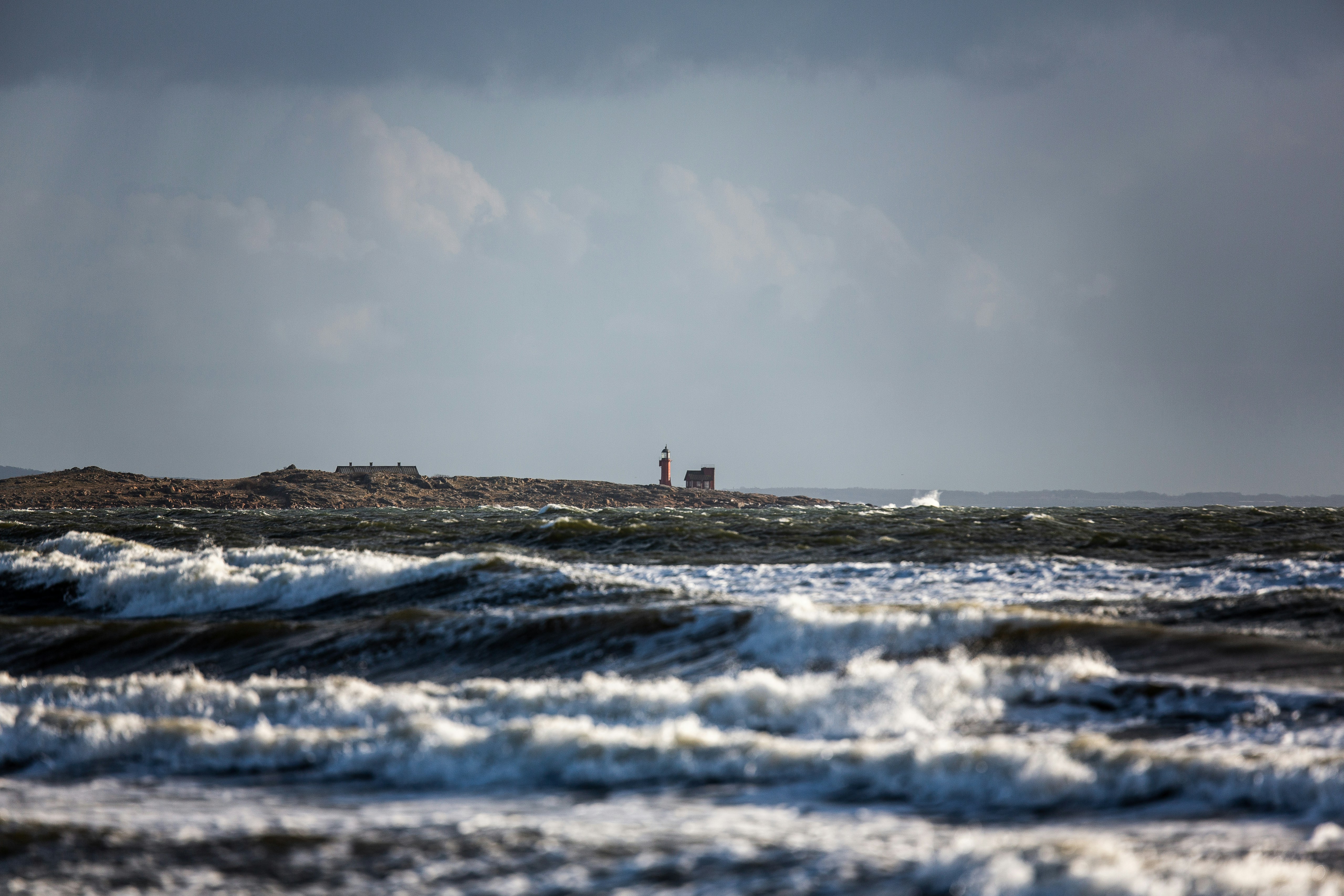 Ein Leuchtturm auf einer kleinen Insel mitten im Ozean