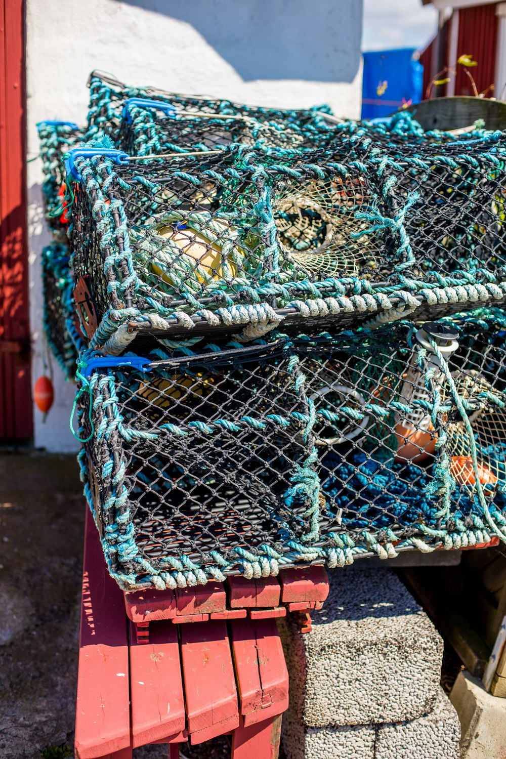 a pile of lobster traps sitting on top of a red bench