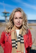 a woman wearing a red jacket and scarf