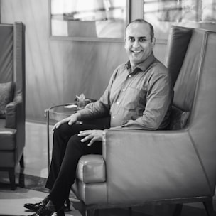 A man smiling relaxed at home, feeling relief after using natural hemorrhoid remedies.