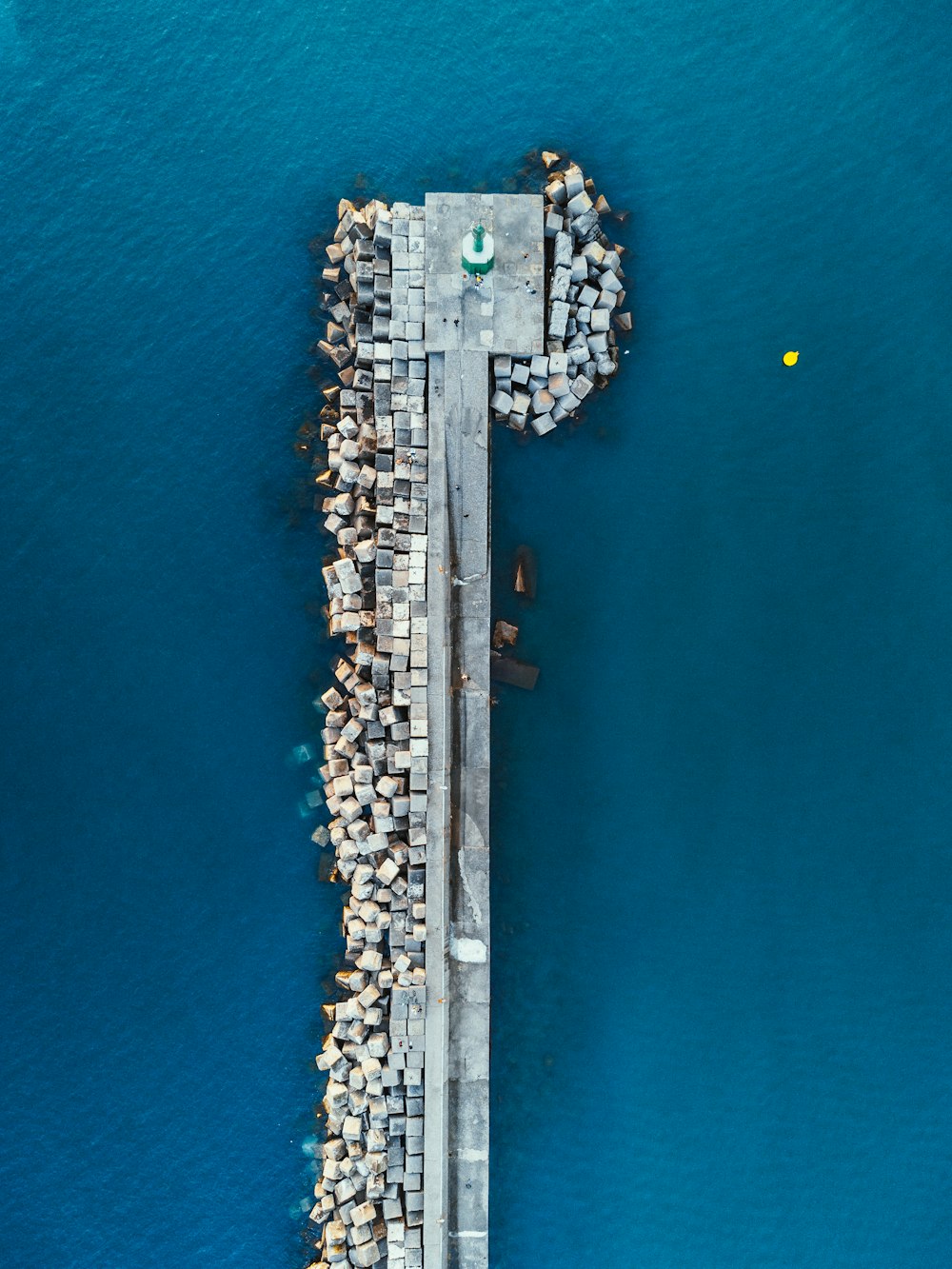 an aerial view of a pier in the middle of the ocean
