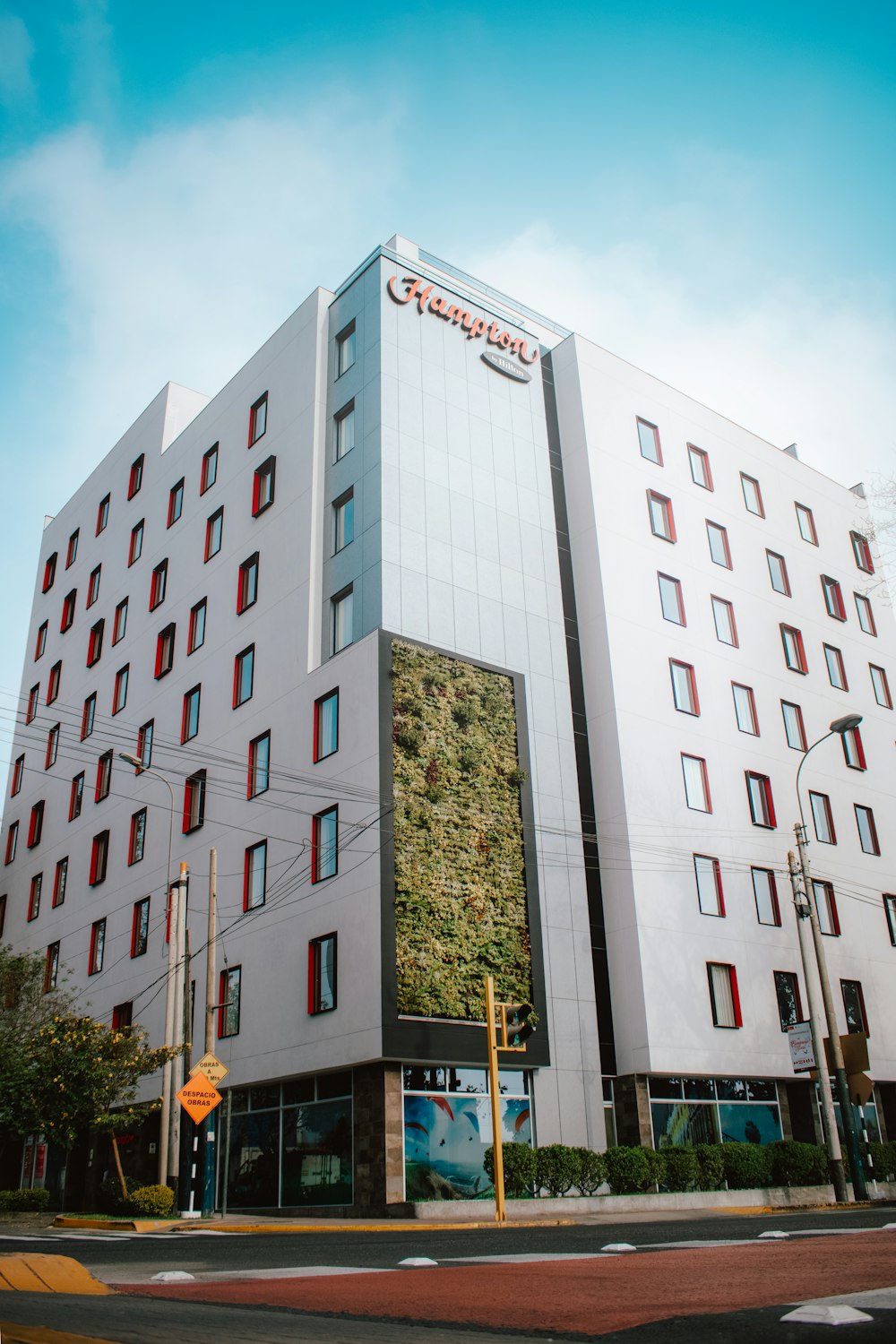 a large white building with a green plant on the side of it