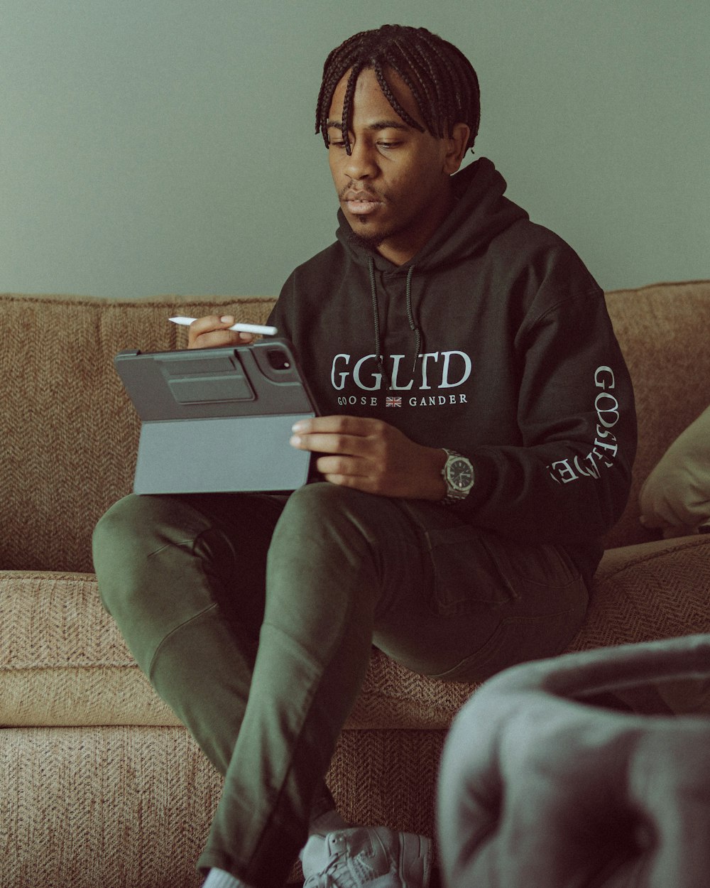 a man sitting on a couch holding a laptop