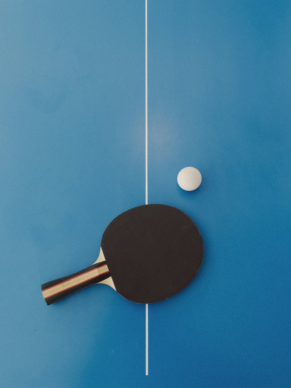 a ping pong paddle and a ping pong ball