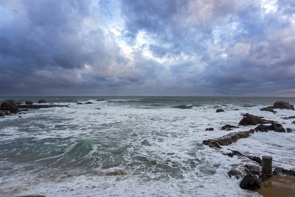 a rocky beach with waves coming in to shore